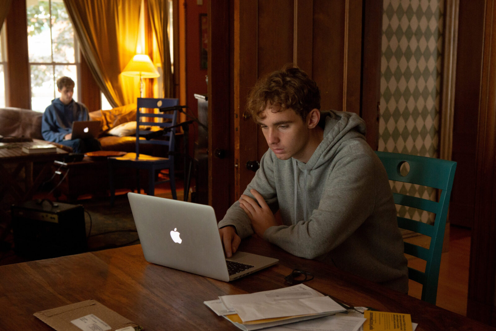 A student on a computer in a dark living room.